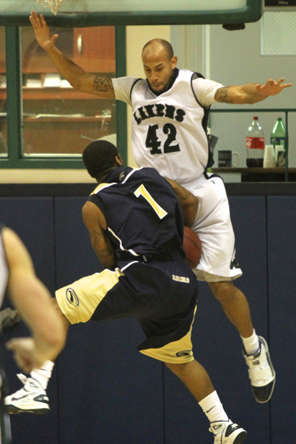 Photo by Ethan Magoc: Mercyhurst College's Bill Weaver (42) fouls Clarion University's Lloyd Harrison while trying to block his layup during the second half on Wednesday, Jan. 19, 2011, at the Mercyhurst Athletic Center.